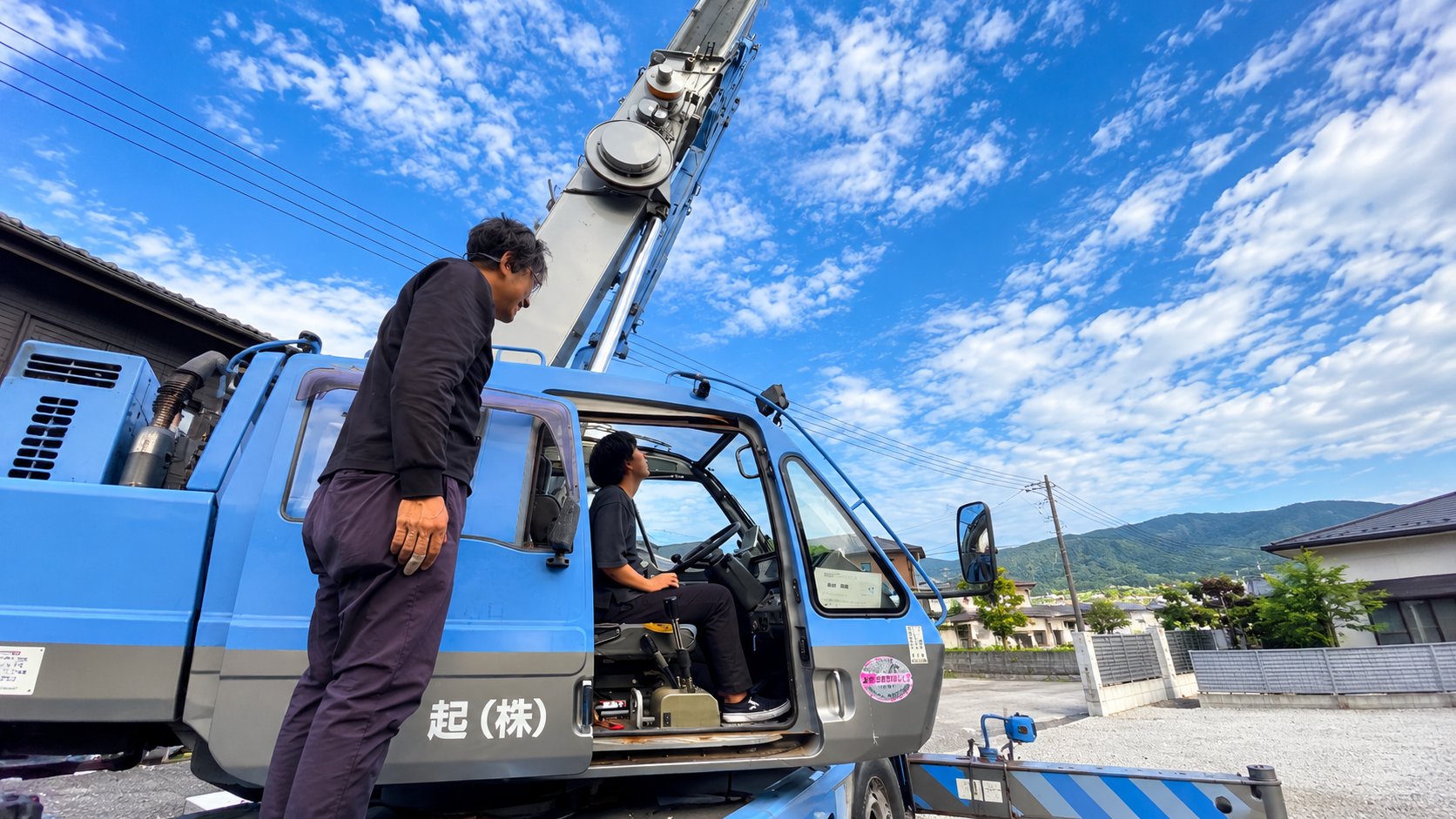 クレーン車の運転席に座る社員